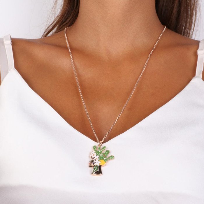 Metal necklace with pendant of a woman's dark head with colored enamels and crystals